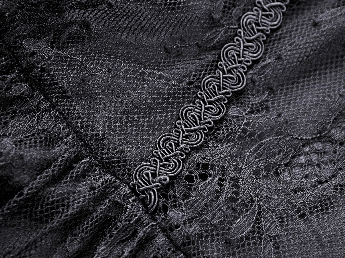 Macro close-up of black lace with decorative embroidered cord trim and mesh weave