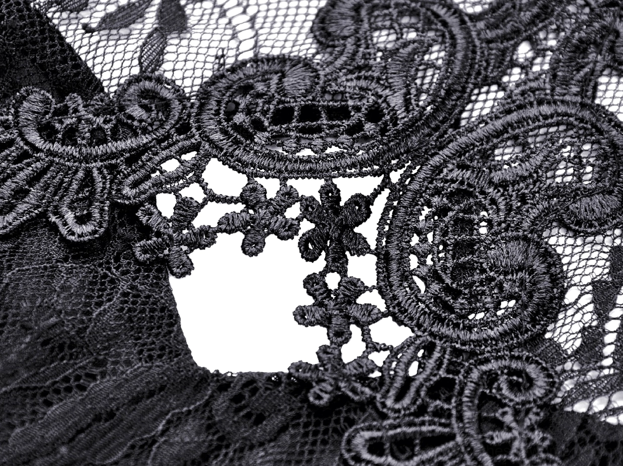 Close-up macro detail of intricate black floral scroll lace pattern on gothic dress