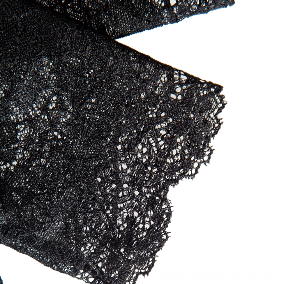Close-up overhead shot of black lace fabric texture, showcasing the intricate floral detail and gothic aesthetic quality