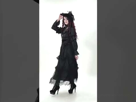 Black floor-length gothic lace skirt side profile on model with headwear, showing high-waisted silhouette and romantic tiered construction