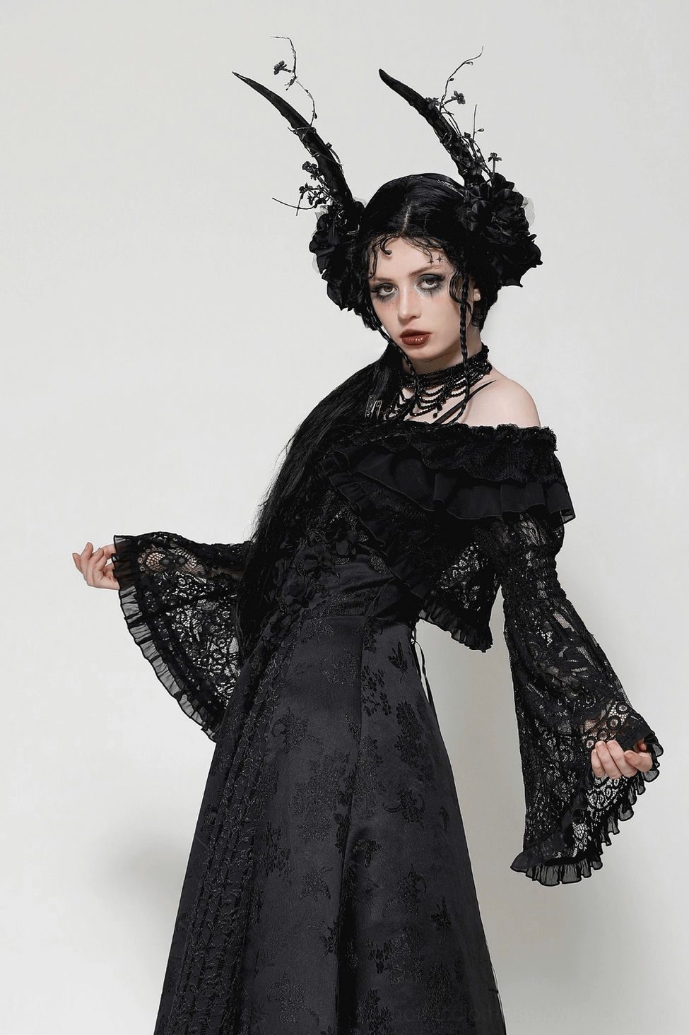 Off-shoulder gothic lace cape displayed on model showing neckline ruffles and dramatic bell sleeve flow