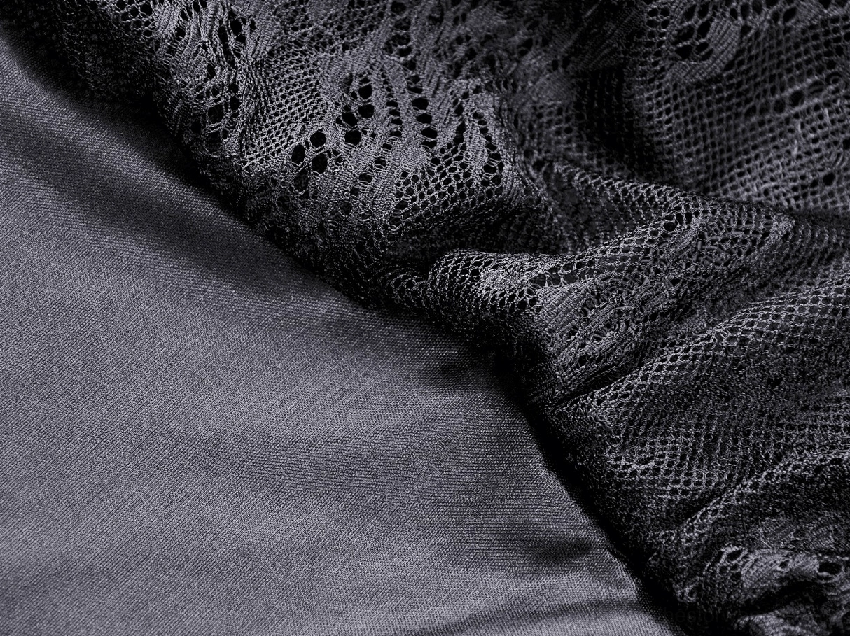 Close-up detail of black satin and lace fabric blend on gothic dress with draped texture