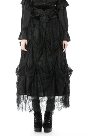 Black lace tiered high-waist maxi skirt worn by female model with matching black blouse, front full-body view showing draped lace panels and scalloped hemline in studio setting