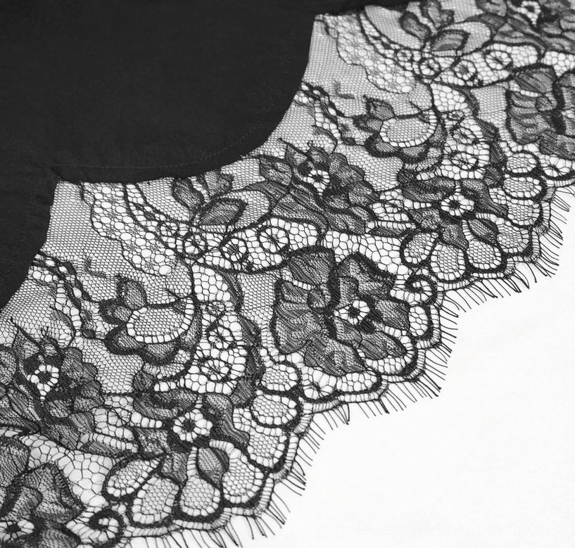 Close-up of intricate black lace trim detail on gothic dress sleeves, showing fringed edges and elaborate floral lace pattern