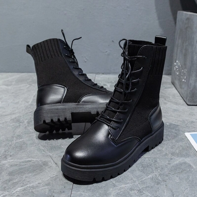 Black gothic platform combat boots angled front view - lace-up closure smooth leather toe cap on marble background
