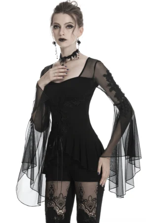 Black lace-up gothic top with sheer floral mesh sleeves and ruffled hem, front three-quarter view on model