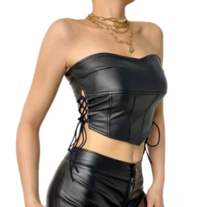 Black latex backless crop top with side lace-up ribbon closures and sweetheart neckline, worn by model in outdoor daylight setting