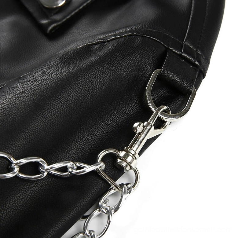 Close-up detail of black faux leather texture, silver chain hardware and buckle accents