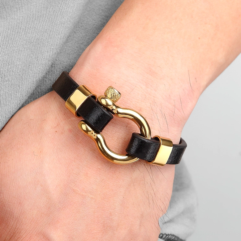 Black and gold leather toggle bracelet on male wrist, side view demonstration of fit and gothic aesthetic wear