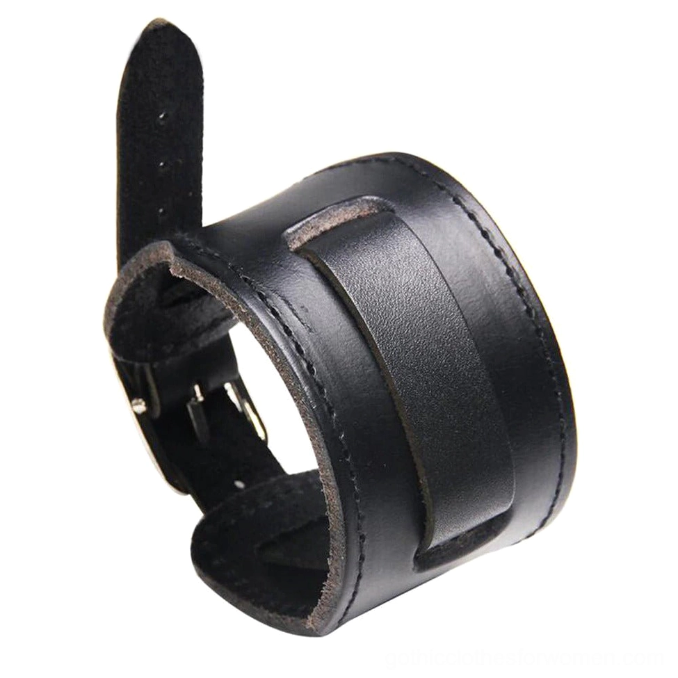 Black wide leather gothic wristband with metal hardware and embellished panel, matte finish leather texture, three-quarter view on clean white surface