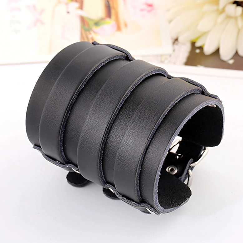 Front oblique view of matte black leather gothic cuff bracelet featuring silver metal hardware accents and buckle design
