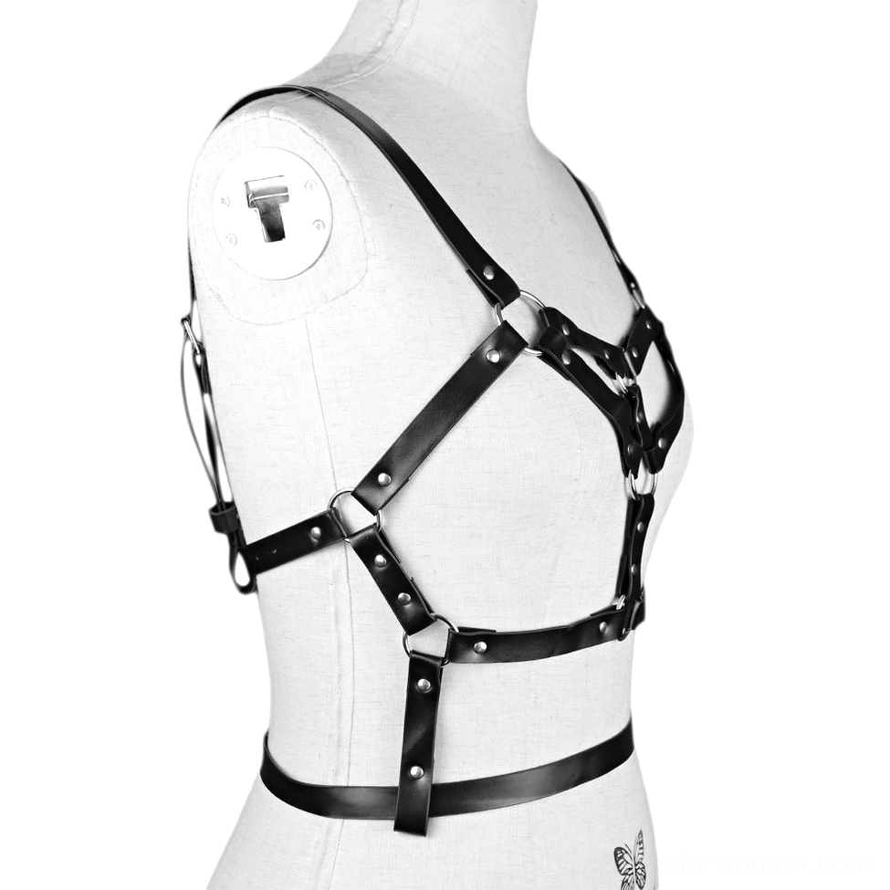 Black faux leather adjustable body harness detail shot of metal rivets, O-rings, and hardware construction