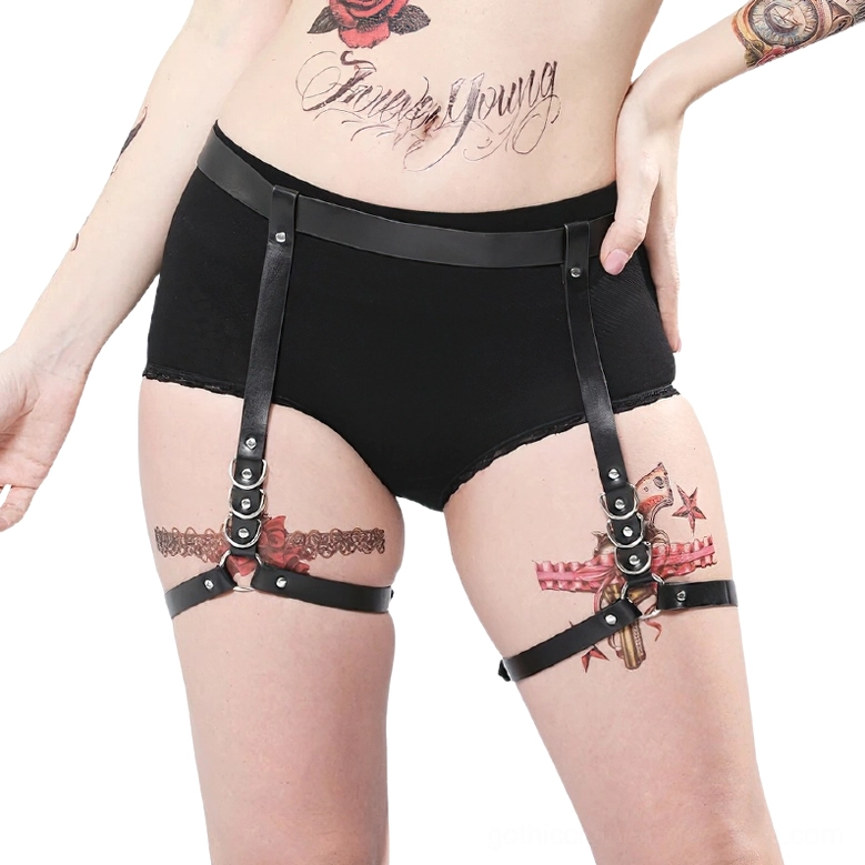Black leather harness for women front view on tattooed model showcasing gothic aesthetic and adjustable body straps