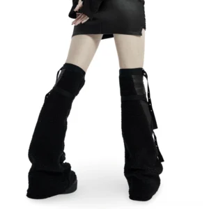 Black punk leg warmers with side buckle straps and fuzzy cashmere texture, rear view on model wearing leather skirt