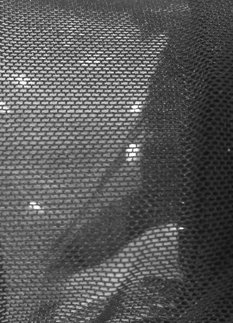 Macro close-up of fine woven black mesh fabric texture on fingerless glove