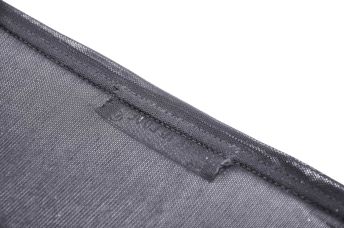 Close-up detail of woven brand label tag and clean seam construction on gothic mesh top