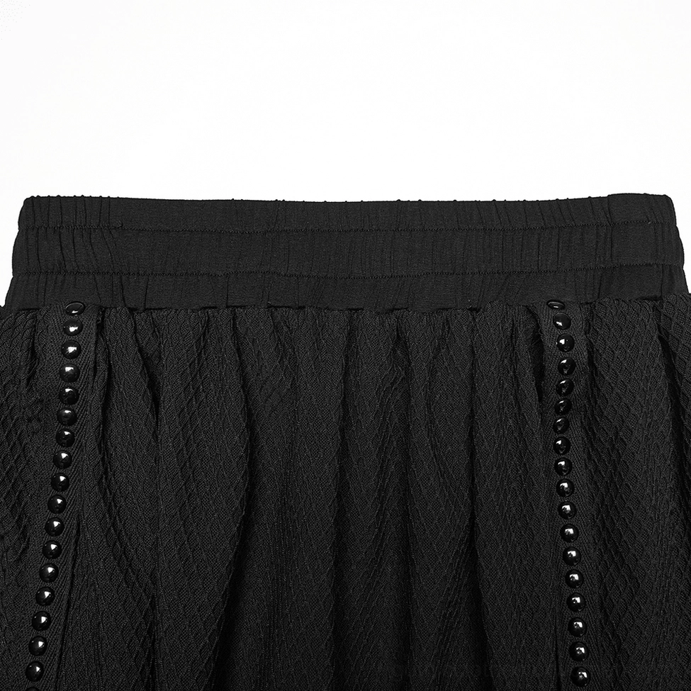 Close-up detail of black mesh skirt elastic waistband and studded side trim embellishments