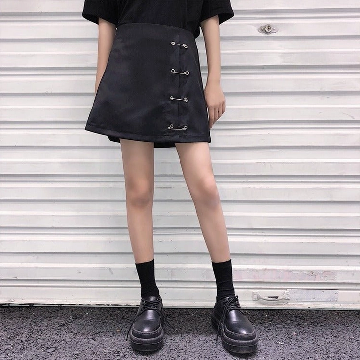 Black A-line safety pin mini skirt showing mini length and silhouette, full front model shot alternative styling