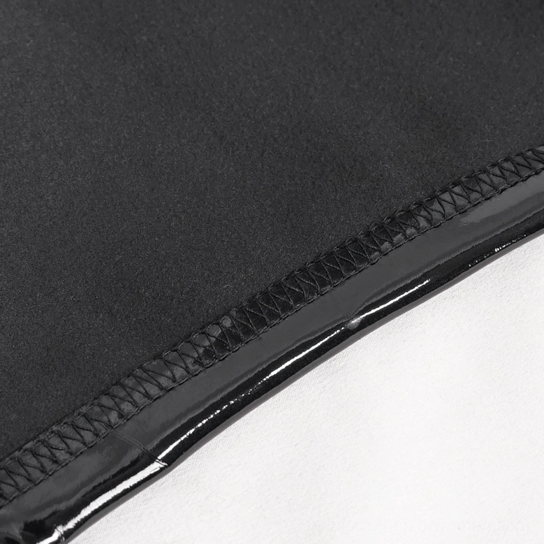 Detailed view of black patent leather gothic shorts showing texture, glossy finish, and lace-up construction