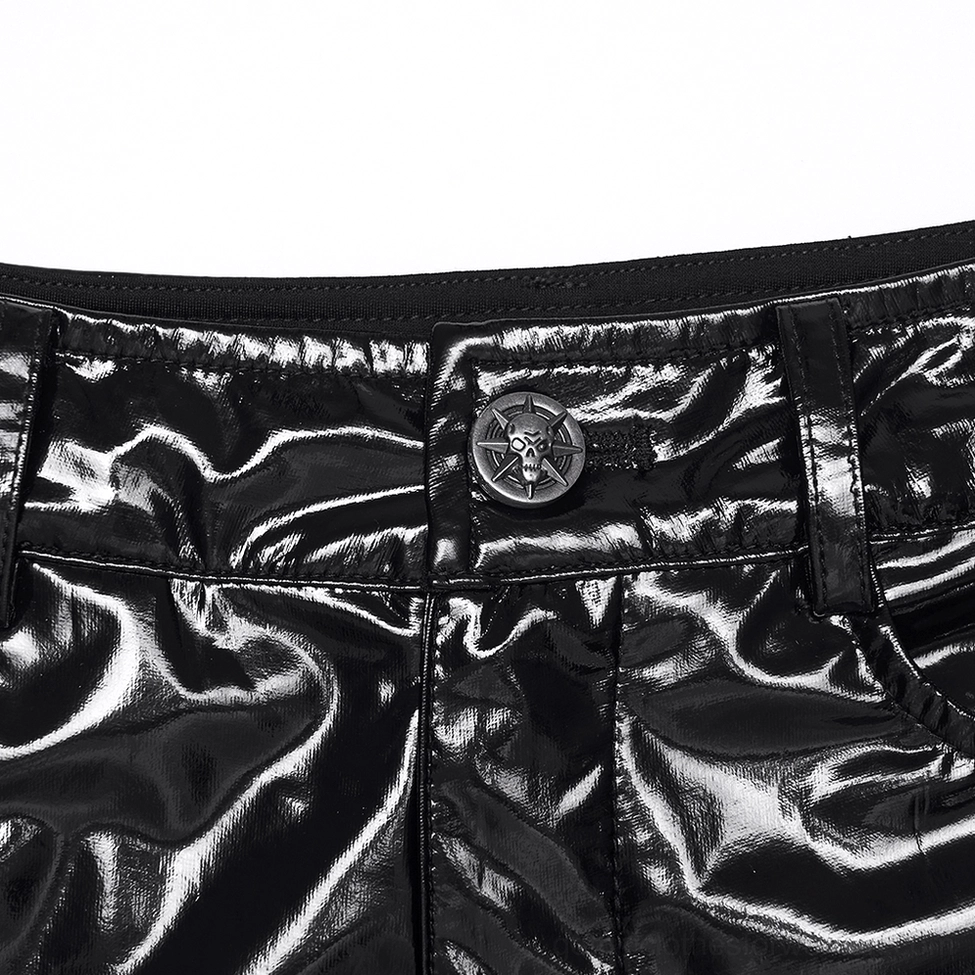 Close-up waist detail of black patent shorts - showing embossed metal button closure