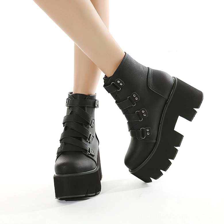 Model styling black platform ankle boots front-side leg perspective, multiple buckle decorations visible on chunky sole