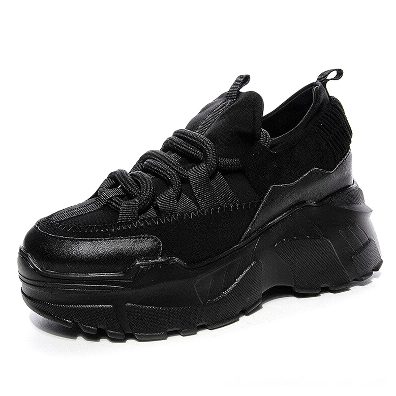 Black women's platform leather sneakers with thick lug sole and lace-up closure, front three-quarter studio view