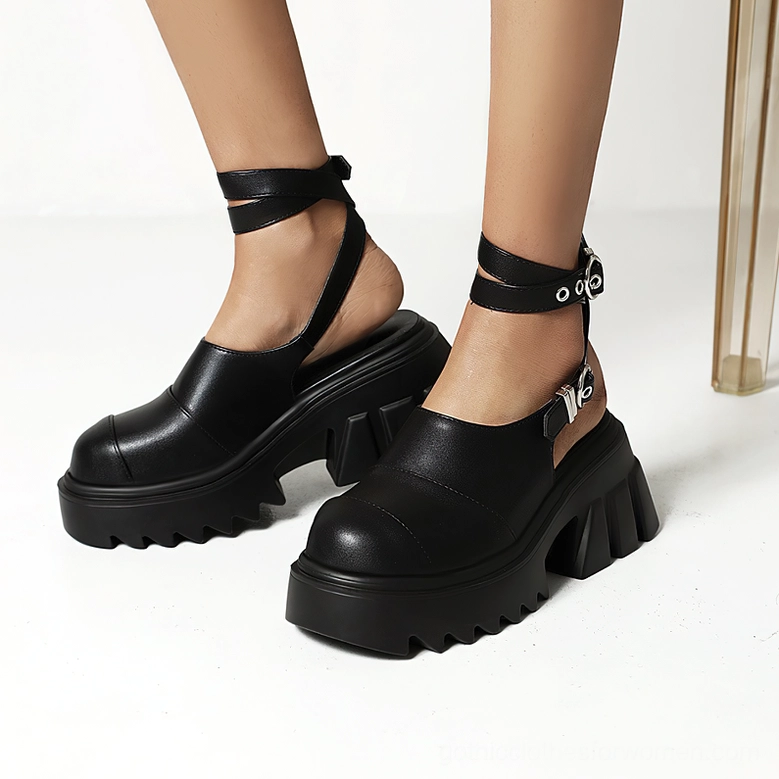 Black gothic platform sandals worn on model - chunky lug sole and ankle buckle strap detail