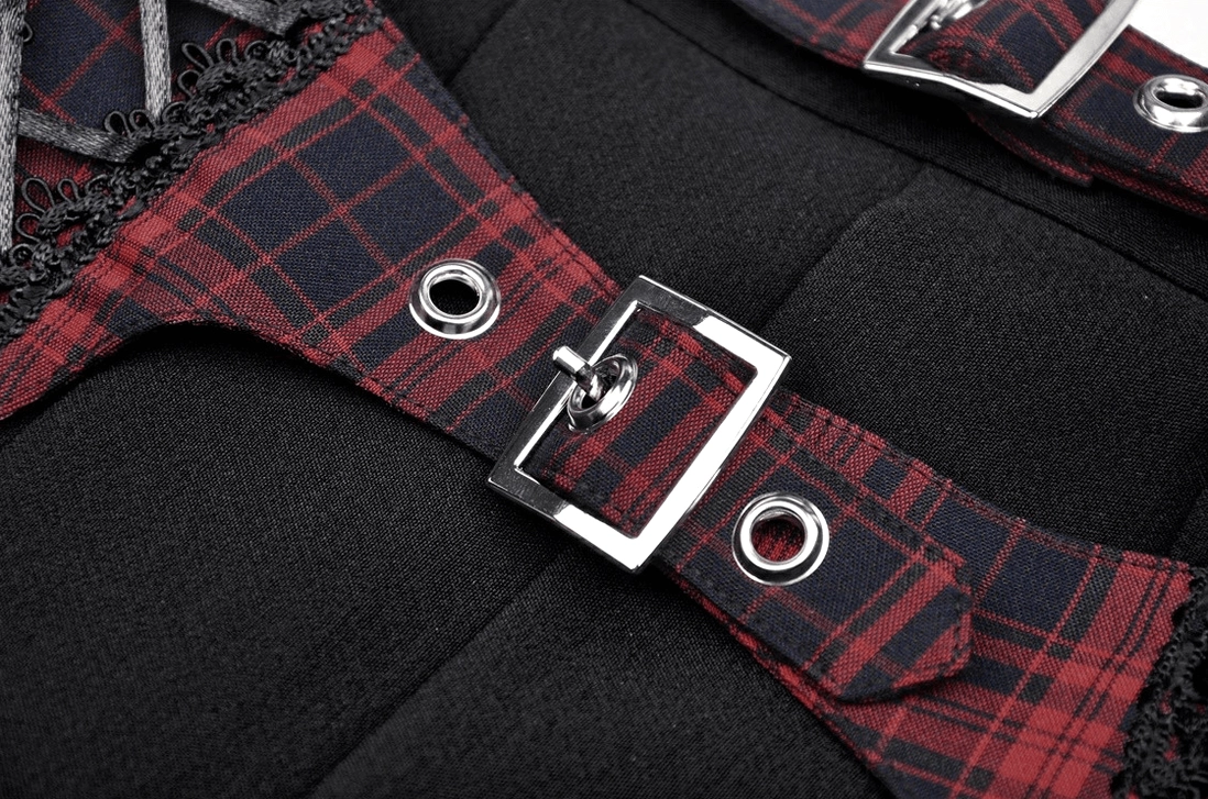 Close-up of silver square metal buckles and red tartan straps with eyelet holes on gothic skirt