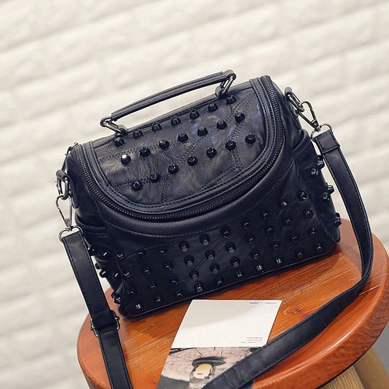 Studded sheepskin leather crossbody bag exterior showcasing dark leather finish and intricate rivet pattern for alternative fashion styling