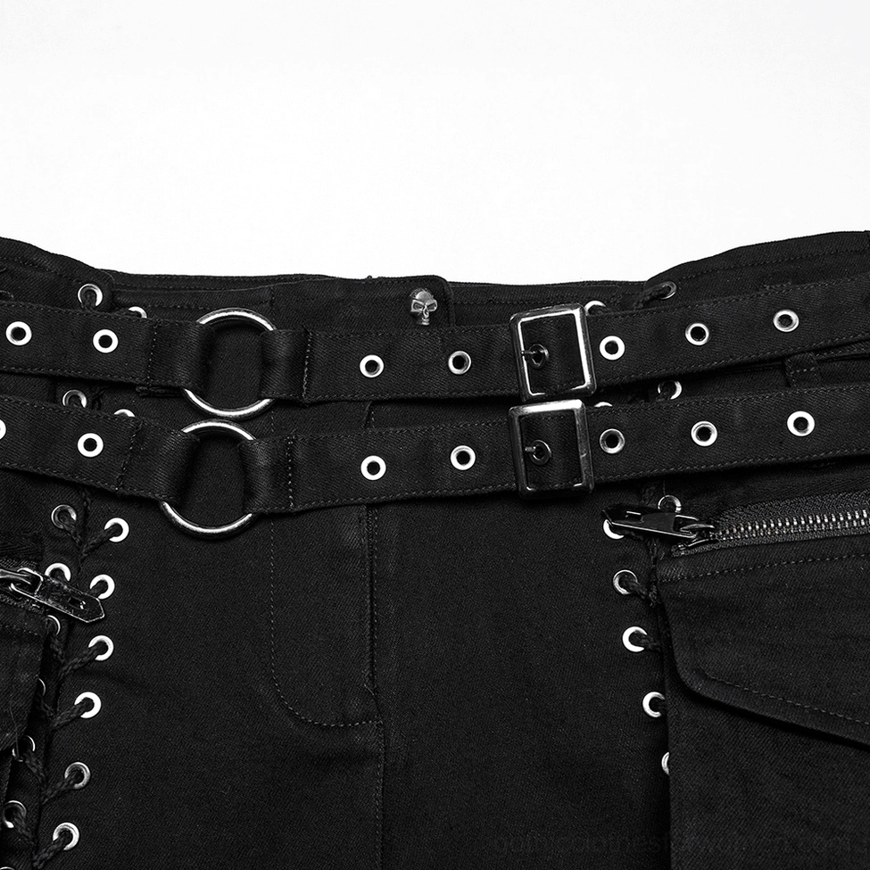 Close-up detail of black shorts waistband featuring double metal buckle belts, metal lace eyelets, and zippered side pocket closure