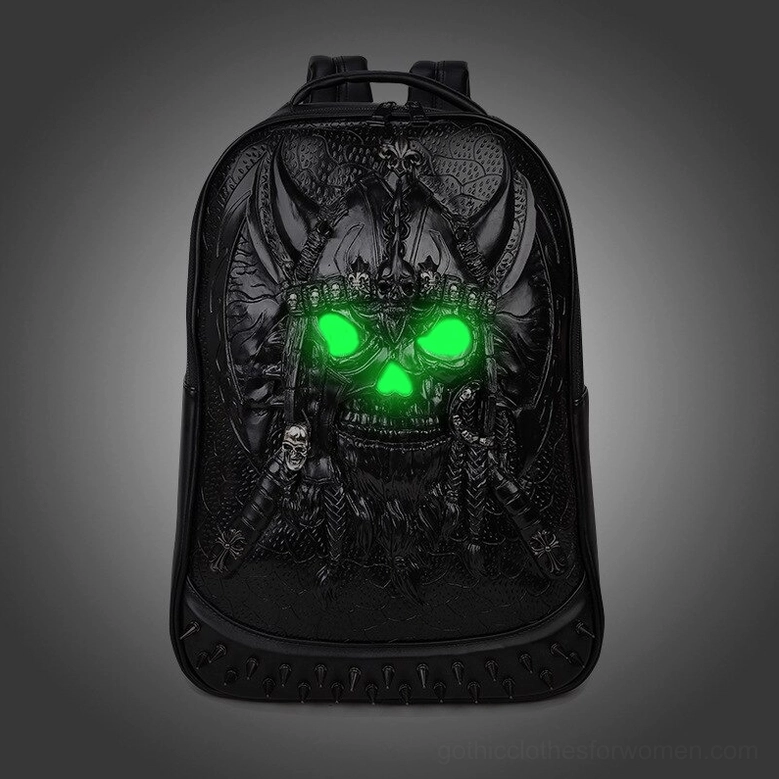 Black embossed viking skull backpack with green glowing eyes on dark background gothic aesthetic