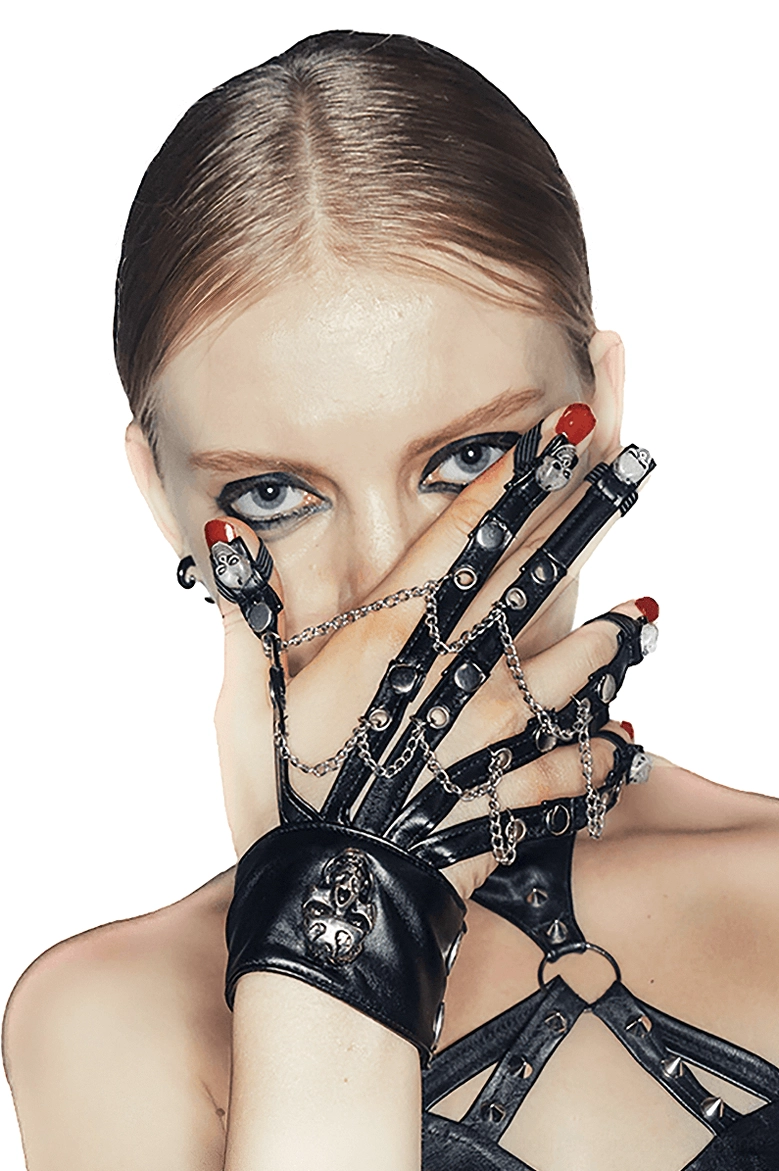 Woman wearing black gothic fingerless leather gloves with skull motifs, close-up hand portrait with dark makeup