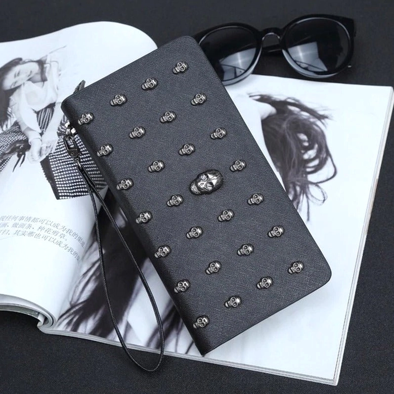 Right front view of cross-textured black PU leather gothic skull wallet with silver studs, central skull ornament, paired with sunglasses on magazine aesthetic