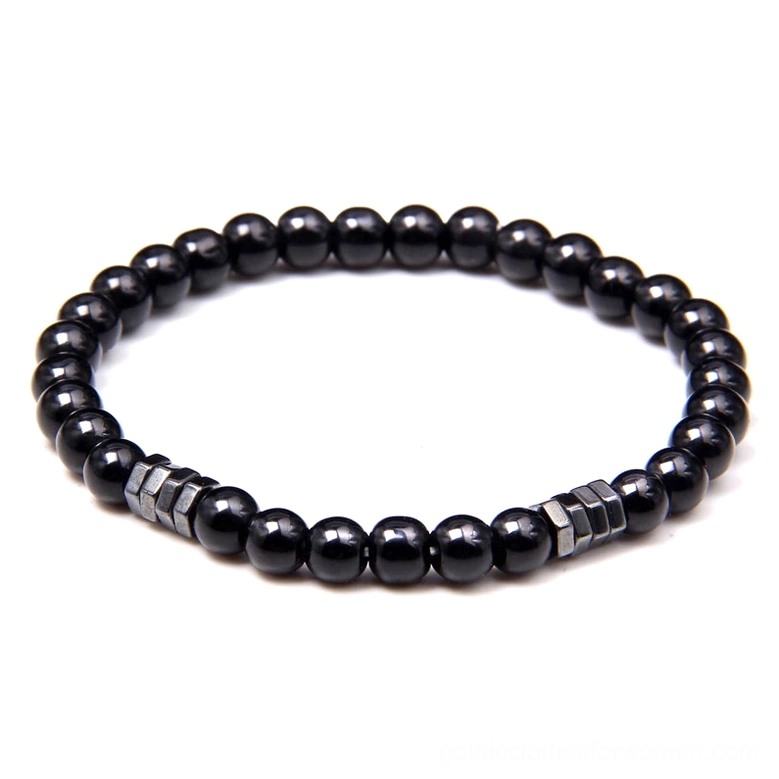 Black beaded bracelet with silver metal spacer accents flat lay view polished stone beads dark minimalist jewelry
