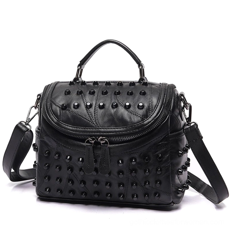 Black studded sheepskin leather crossbody messenger bag with dual front zippers and removable shoulder strap, front three-quarter view showing gothic aesthetic details