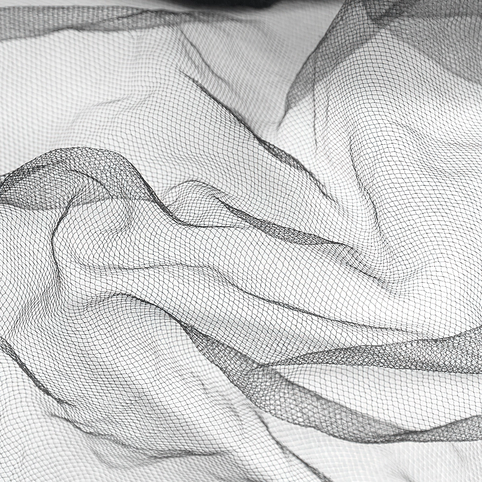 Close-up detail of black illusion tulle fabric texture showing sheer netted weave and wrinkled surface
