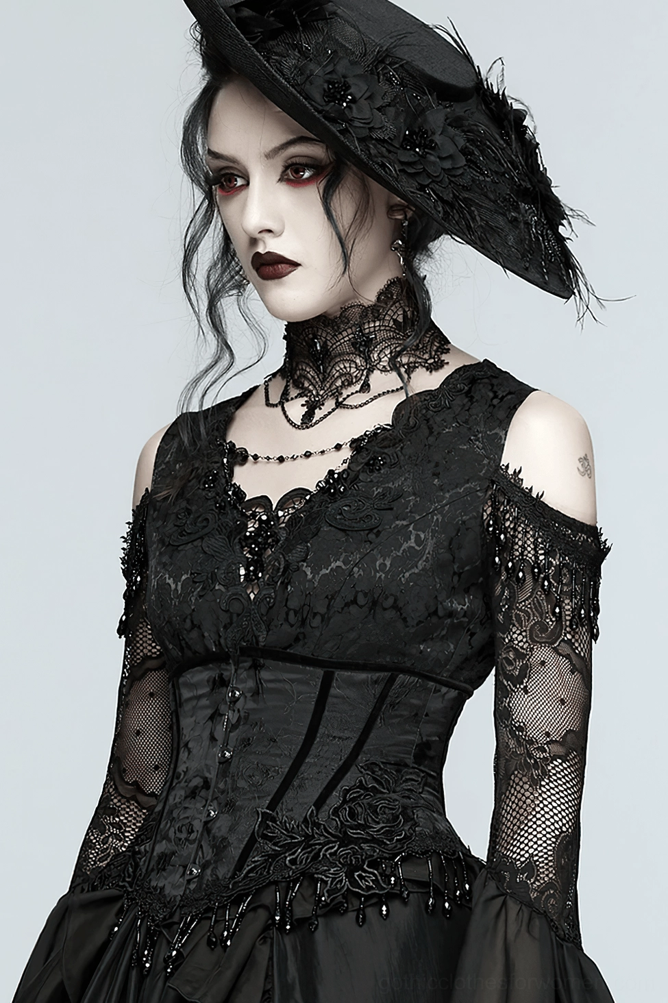 Black underbust corset with beaded lace-up back and decorative tassel fringe detail