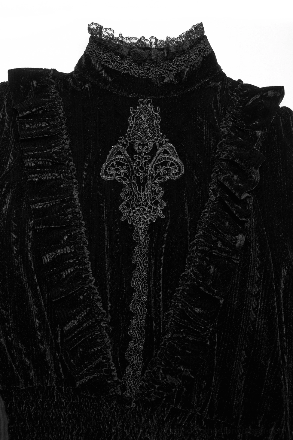 Close-up detail of black velvet Gothic blouse front neck showing vintage embroidery panel and ruffled side frills with lace accents