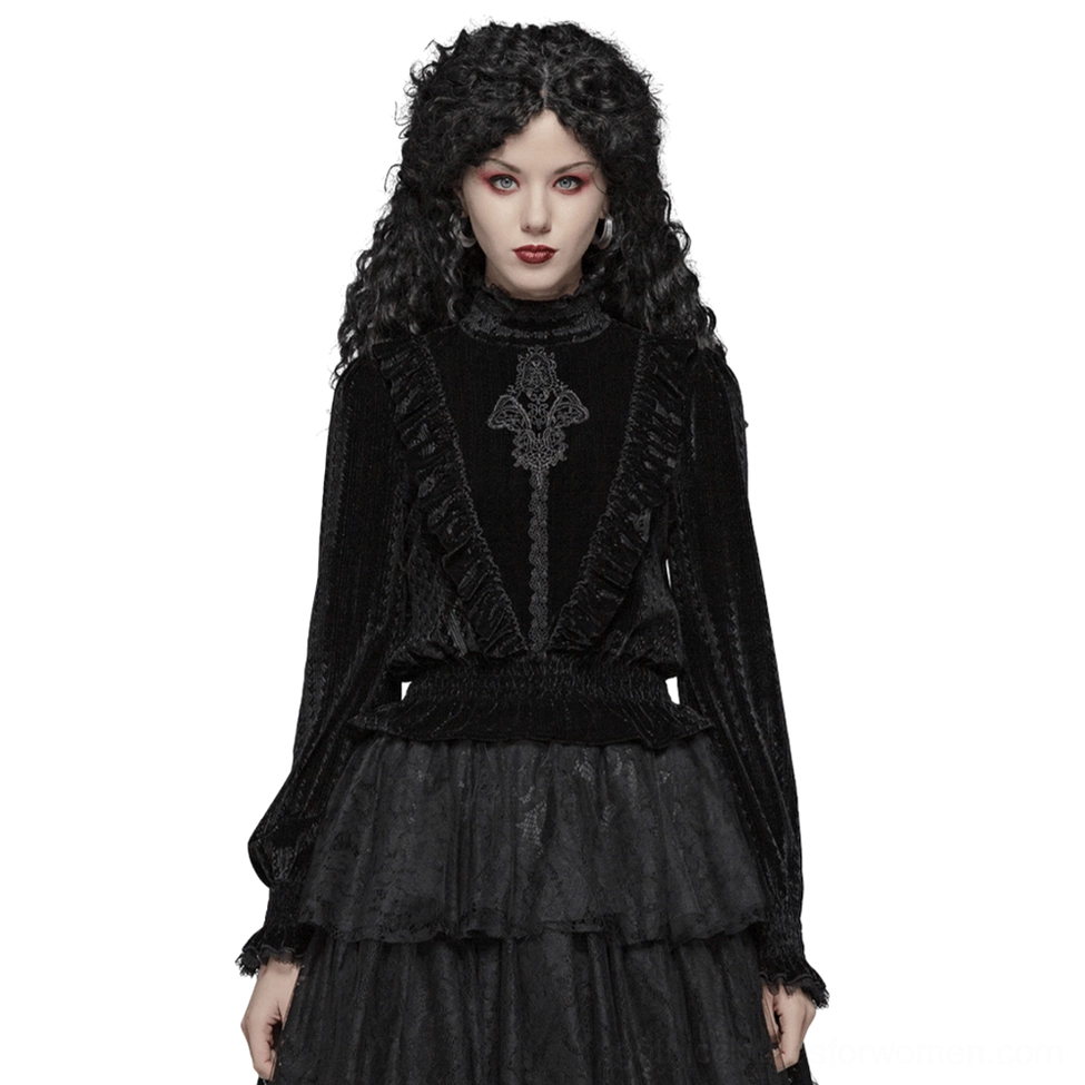 Black velvet Gothic blouse with dramatic ruffle collar and lace trim worn by model with curly black hair in front view, showcasing embroidered front and shirred waist details