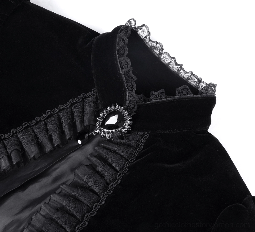 Close-up of gothic velvet bolero collar with gem-studded brooch closure and lace trim details