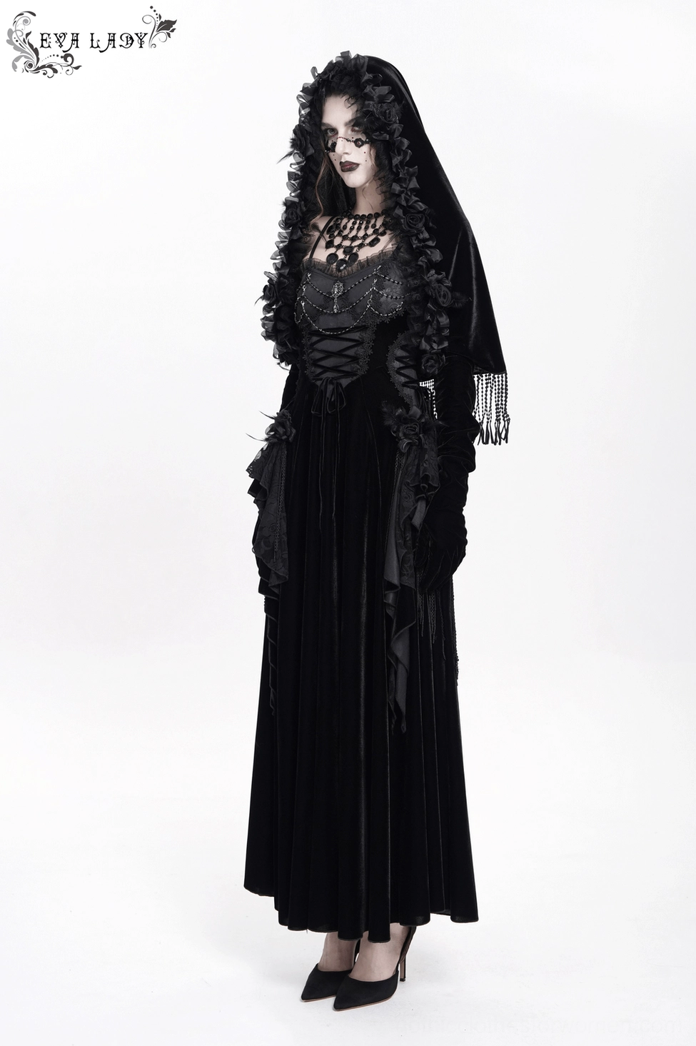 Gothic black velvet hooded cape on mannequin showing structured fit and voluminous sleeve design with beaded fringe