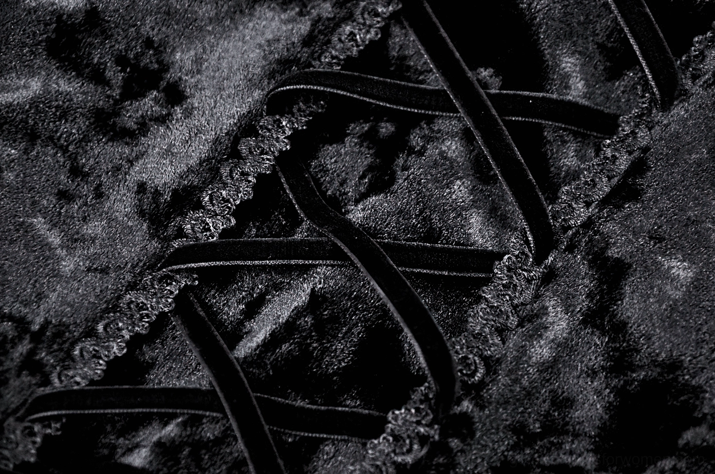 Macro detail of black crushed velvet fabric texture with ruffled trim edges on gothic maxi dress