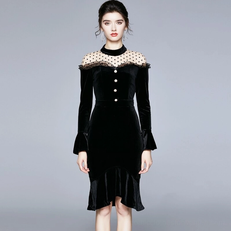 Black velvet gothic midi dress front modeling shot with fitted waist and dramatic ruffled fishtail hem on gray studio background