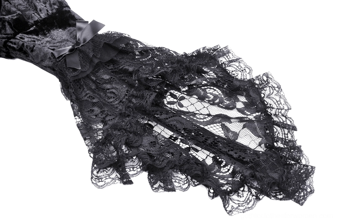 Close-up of scalloped lace cuff and bow accent on black velvet gothic dress