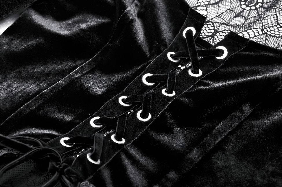 Close-up detail of black velvet gothic dress front lace-up with metal eyelets and spiderweb lace trim