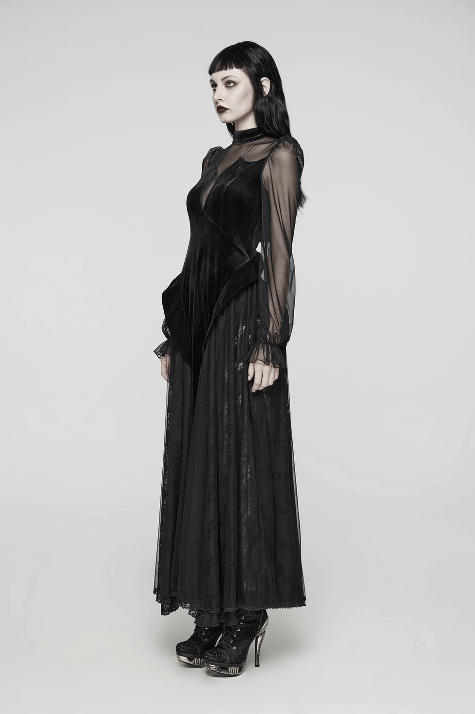 Side profile view of black velvet mesh gothic maxi dress on model featuring batwing sleeves and fitted bodice