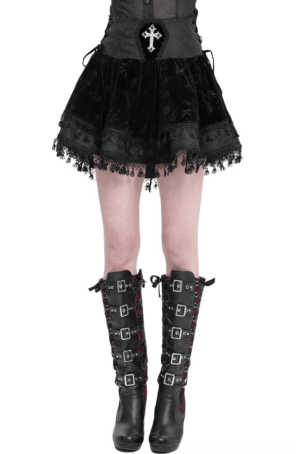 Black velvet gothic mini skirt with embroidered cross waist and lace-up corset front, paired with black buckled knee-high boots, showing front view