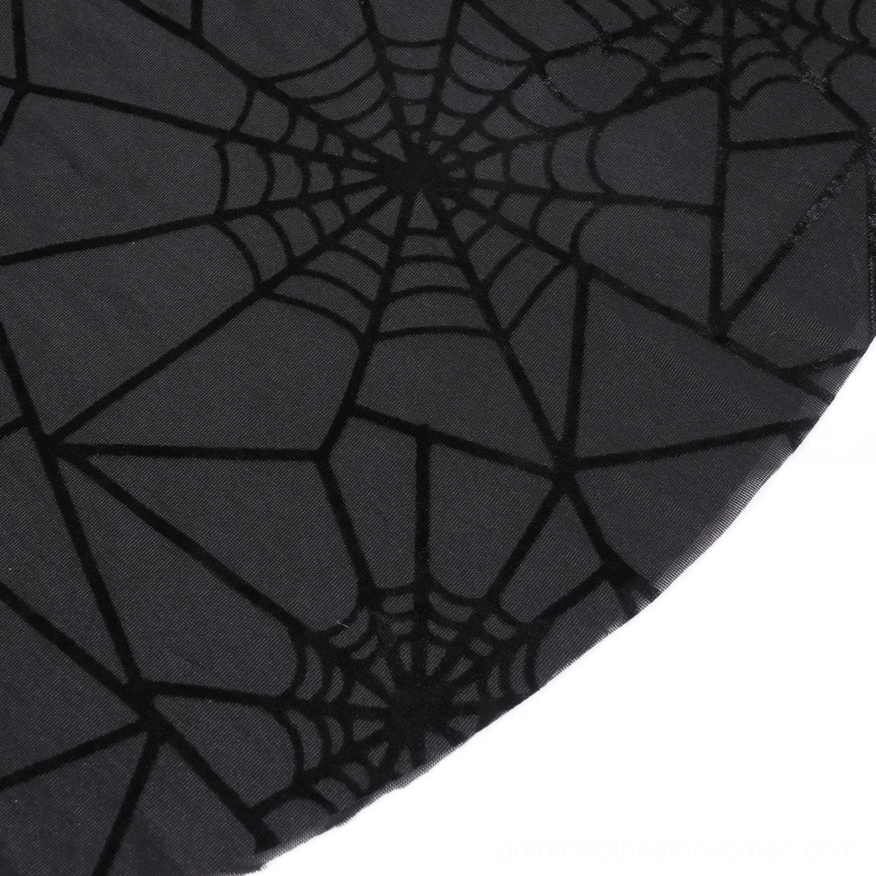 Close-up texture of black spiderweb velvet print on sheer mesh fabric - gothic flare pants detail