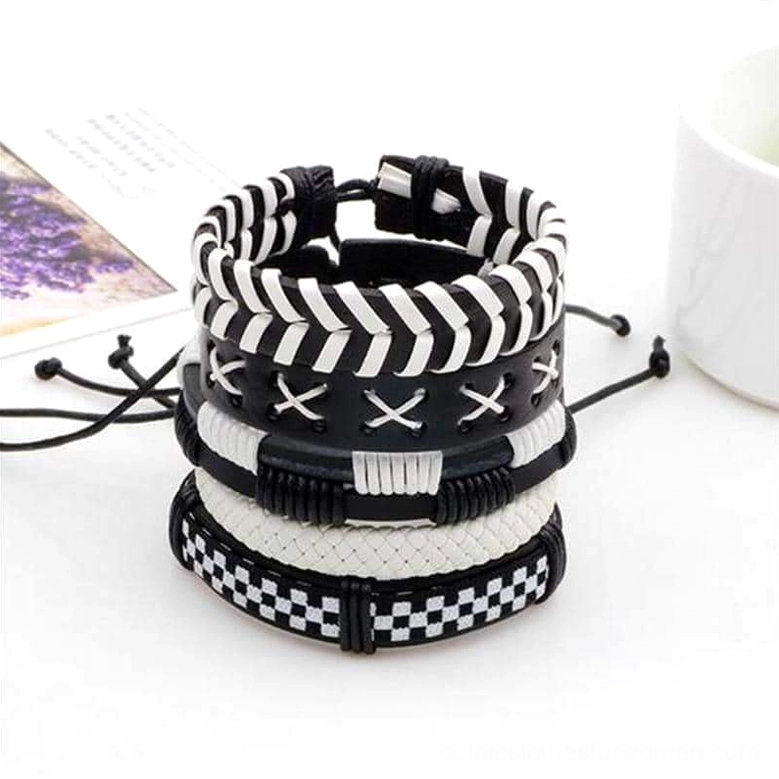 Five-piece black and white gothic leather bracelet set styled on tabletop with magazine and accessories in modern scene