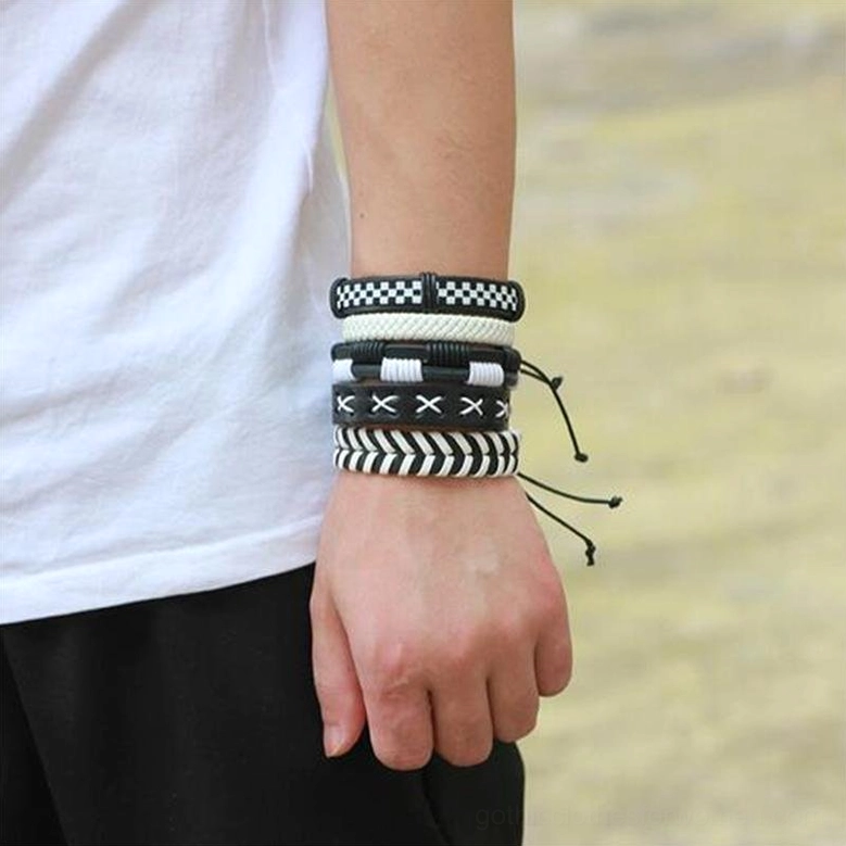Black and white leather bracelets worn on male wrist in outdoor setting showing mixed geometric bracelet styles and fit